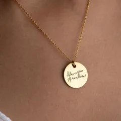 Turn a cherished memory into a timeless keepsake. This round gold pendant is engraved with a loved one's actual handwriting, "I love you grandma", creating a uniquely personal and sentimental piece of jewelry.
