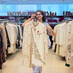 This is a classic groom's sherwani, one of my most popular rental items. It features intricate floral embroidery on an ivory base with a matching stole and a royal chain accessory, offering a complete, regal look.