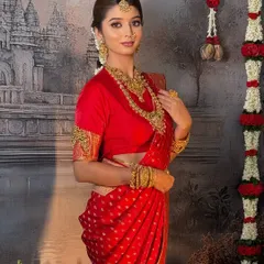 A timeless South Indian bridal look in a classic red Kanchivaram saree. The drape is complemented by heavy temple jewellery for an authentic and regal feel.