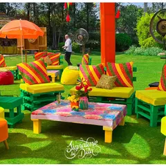 I used brightly painted pallet furniture with colorful striped cushions to create casual and fun seating areas for the Holi party, perfect for a relaxed outdoor gathering.