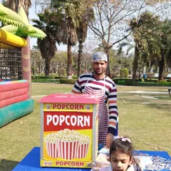 A young guest enjoying a cup of freshly made popcorn from my stall. It's a simple and beloved treat for all ages.