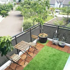 A simple and functional balcony setup. We used artificial grass and wooden tiles to create a clean, green space with a small seating area, perfect for enjoying the neighborhood view.