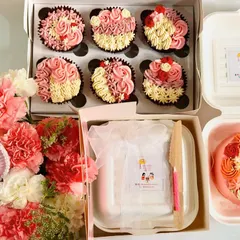 A full Mother's Day spread. This shows how you can combine our offerings for a grand gesture, featuring a bento cake, a box of cupcakes, and a flower hamper with a custom tag.