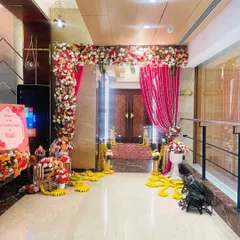 This is the entrance to a vibrant Haldi ceremony. I used a combination of pink drapes and marigold flower arrangements to create a festive and welcoming pathway for guests.