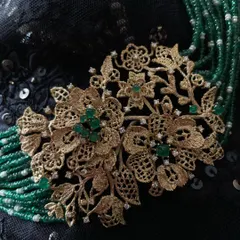 A close-up of my floral lace choker. The centerpiece is a bouquet of flowers and leaves, all hand-formed from textured 18k gold, accented with diamonds and emeralds, and strung with rows of emerald beads and freshwater pearls.