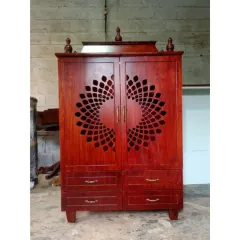 A compact, standalone pooja mandir crafted from rich, dark wood. The doors feature a beautiful laser-cut circular pattern, and the unit includes drawers for storing pooja essentials, making it perfect for smaller spaces.