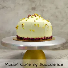 For Ganesh Chaturthi, I offer a modern take on a traditional sweet with my signature Modak Cake. This 100% eggless cake is shaped like a modak and delicately flavored, garnished with premium pistachios and edible rose petals for an elegant finish.