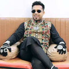 Relaxing for a moment before the show. Even when seated, the style speaks for itself with this colorful vest and traditional accessories.