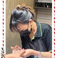 Our nail artist, known for her elegant transformations, is seen here concentrating on the fine details of a client's nail art.