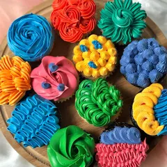 A vibrant set of cupcakes inspired by the movie 'Inside Out'. Each cupcake is frosted with brightly coloured buttercream using different piping styles to represent the emotions of Joy, Sadness, Anger, Fear, and Disgust.