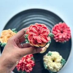 A close-up of a two-toned dahlia cupcake, showing the delicate petal work.