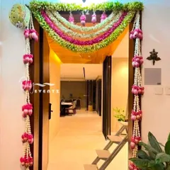 We create stunning main door decorations for housewarming ceremonies. This elegant design features garlands of fresh jasmine and pink lotus buds, creating a beautiful and auspicious welcome for your guests.