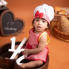 Celebrating six months with a fun baker theme! The props and costume come together to create a memorable half-birthday portrait that is full of character.