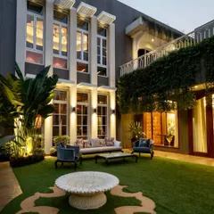 Even in the heart of the city, you can have a tranquil outdoor sanctuary. I transformed this urban bungalow's courtyard into an elegant evening lounge, using strategic lighting on palms and a patterned lawn to create a sophisticated and private green space.