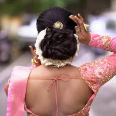 A classic floral bun, perfect for a Muhurtham or reception look. I've created a neat, voluminous bun and encircled it with fresh white jasmine (Mallige), ensuring the flowers are stitched in place so you can move freely without any worry.