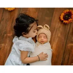 A gentle kiss for her new baby brother. This is the kind of heartwarming, unscripted moment that tells a beautiful story of sibling love.