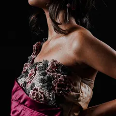 A detailed shot focusing on the intricate floral embroidery on the bodice of a custom gown. For lookbooks, I make sure to capture these close-ups that showcase the unique quality and hard work put into each piece.