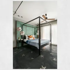 A home should reflect the passions of its owners. This bedroom in the Kamala Residence was inspired by the client's love for deep-sea diving, featuring marine life patterns laser-cut into the oxide flooring and a sea-green patina wall, making the space deeply personal.