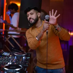 I do more than just play music; I connect with the crowd and keep the energy high all night. Here I am on the mic, making sure everyone is part of the experience.