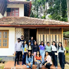 A group photo in front of a traditional Kerala-style homestay, our comfortable base for exploring Wayanad.