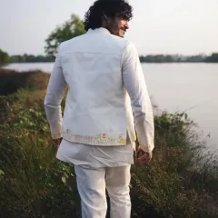 A back view of Vishak Nair's premiere outfit, highlighting the clean tailoring and the subtle, artistic embroidery along the hem of the jacket.