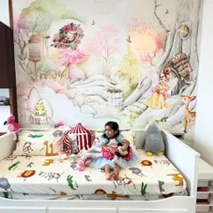 A little girl enjoys her magical new room, complete with a whimsical fairy and enchanted forest mural that turns her bedroom into a storybook.