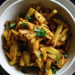 A simple and comforting bowl of aloo fry, seasoned with jeera and fresh coriander. It's the perfect side dish for a rainy day with hot khichdi.