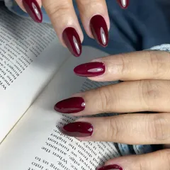 A classic and elegant solid color manicure in a deep cherry red. Applied on perfectly shaped almond nails, this glossy finish is a timeless statement of confidence and style.