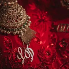 A macro shot of a custom kalire charm with the couple's initials 'LD', a small but deeply meaningful detail that tells a personal story.