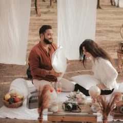 A fun and spontaneous pillow fight during a picnic-style pre-wedding shoot. Capturing these playful moments is key to showing a couple's true dynamic.