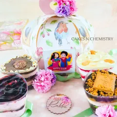 My Rakhi tub cake hampers are a perfect modern gift. This set includes a variety of flavors like Ferrero Rocher, Biscoff, and Blueberry Cheesecake, presented in a beautiful floral gift box.