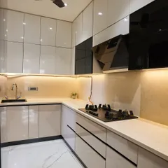 A sleek and modern U-shaped kitchen. The glossy white and black cabinets create a sharp contrast, while the under-cabinet lighting provides excellent task lighting and adds a warm glow.