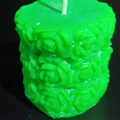 This is my rose-carved pillar candle in a vibrant green. The intricate floral pattern wraps around the entire candle, making it a standout piece.