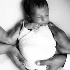 Cradled safely in their parents' hands. In black and white, this pose becomes even more powerful, symbolizing the hope and dreams that come with a new beginning.