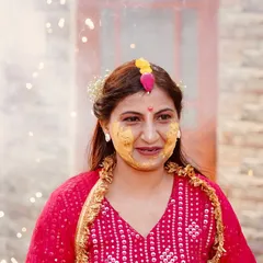 A happy portrait of the bride during her Haldi, with her face covered in turmeric and firecrackers sparkling in the background. This shot captures the celebratory atmosphere perfectly.