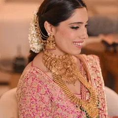 A close-up of a beautiful South Indian bridal look, where the hair is adorned with fresh flowers and traditional gold accessories, creating a look of pure opulence.