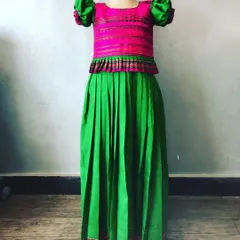 Here is another colour combination for a kids' Paavada blouse, with a pink top and a solid green skirt. The peplum design and puff sleeves are stitched for a very good fit.