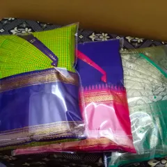 Three sarees, all neatly pleated and packed in clear covers. This box folding method protects the pleats and keeps the sarees ready to wear.