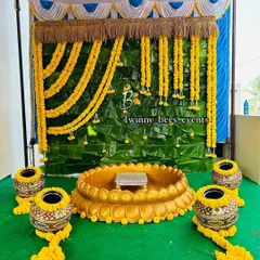 This is another variation of our banana leaf backdrop, designed for a naming ceremony. The setup includes a large lotus-shaped basin, traditional pots (kalasha), and hanging marigold garlands, creating a complete ritual space.