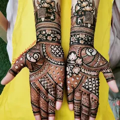 A striking design combining bold, dark henna application with delicate patterns. It features elephant motifs at the top and a mix of floral and geometric elements.