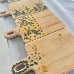 A beautiful collection of wooden chopping boards decorated with pressed flowers and sealed in resin.