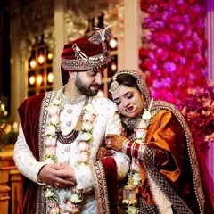 A sweet, candid moment between the wedding couple. The bride rests her head on the groom's shoulder, a simple gesture full of emotion.