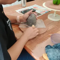 A student carefully carves details into her capsicum sculpture. These focused moments are where the magic happens, as a simple lump of clay begins to take on a life of its own.