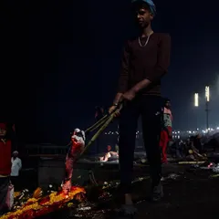 A worker at Manikarnika Ghat tends to a funeral pyre at night. The low light and high contrast highlight the difficult and essential work involved in these final rites, a core part of my documentary series on Varanasi.