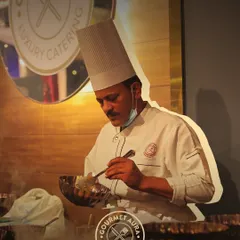 A chef in his element, focused on meticulously preparing a dish over a steaming pot. This image captures the precision and passion that defines our kitchen.