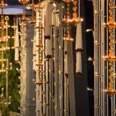A close-up of the divine decor, featuring rows of hanging brass diyas and strings of white flowers, creating a serene and spiritual ambiance.