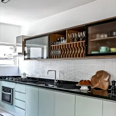 A unique upper cabinet design with integrated wine and glass storage. The mint green base cabinets and mosaic tile backsplash complete this stylish look.