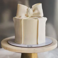 A clean and elegant bow cake, one of my most requested modern designs. The simplicity of the off-white buttercream and the perfectly sculpted bow makes it a statement piece for any occasion.