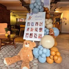 To complement the main decor, I can create smaller themed elements like this "First Year" milestone photo board, beautifully framed with matching balloons and a teddy bear.