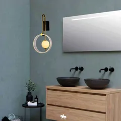 This modern, circular wall sconce adds an artistic touch to a bathroom. The design provides soft, flattering light next to the mirror, transforming a functional space into a small masterpiece.